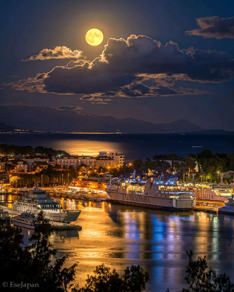 Full moon photo from Marjan overlooking sea port of Split Croatia. Night time near moonrise and mountain, ships and island