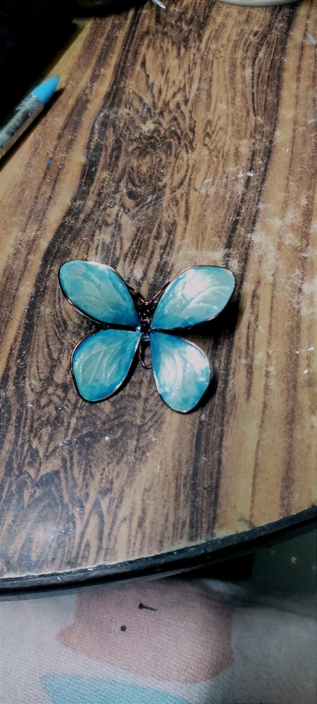 A handmade turquoise coloured butterfly brooch for knit wears.