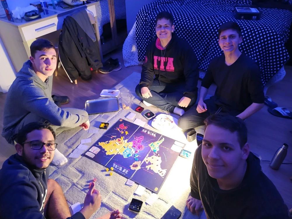 Grupo de amigos reunidos para jogar um jogo de estratégia de tabuleiro.