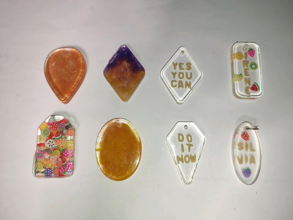 Picture of eight keychains made by myself with epoxy, some of them have colors and others are clear but have text inside