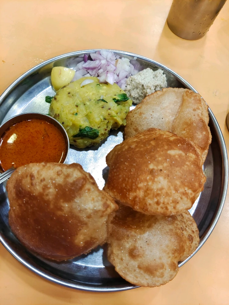 Fluffy hot Puris and aloo ki sabji.. With chutney and onion on top.. Delicious 