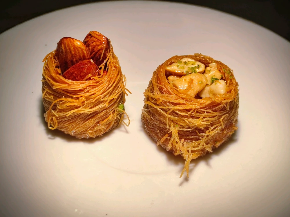 A sweet, flavourful Turkish baklava. 2 baklavas are present, one with almonds and the other with cashews. 