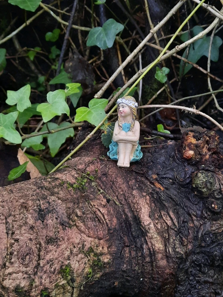 Tiny fairy on a tree branch in the woods