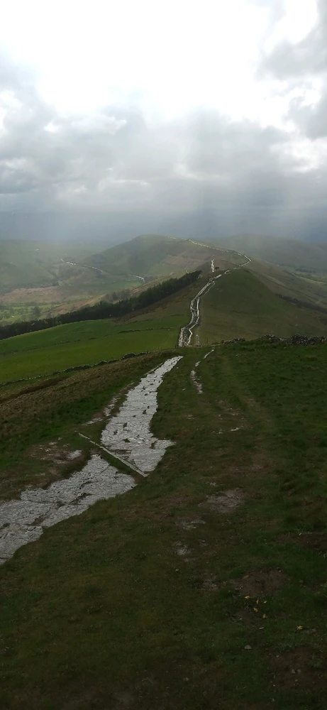 Winding stone slabbed path high up in the hills disappearing into the misty distance as it weaves a way through the terrain.