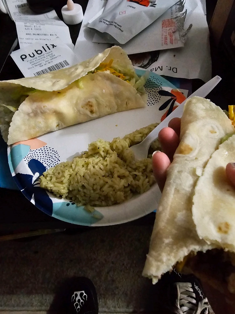 Two gluten and dairy free tacos with cilantro rice on a paper plate.