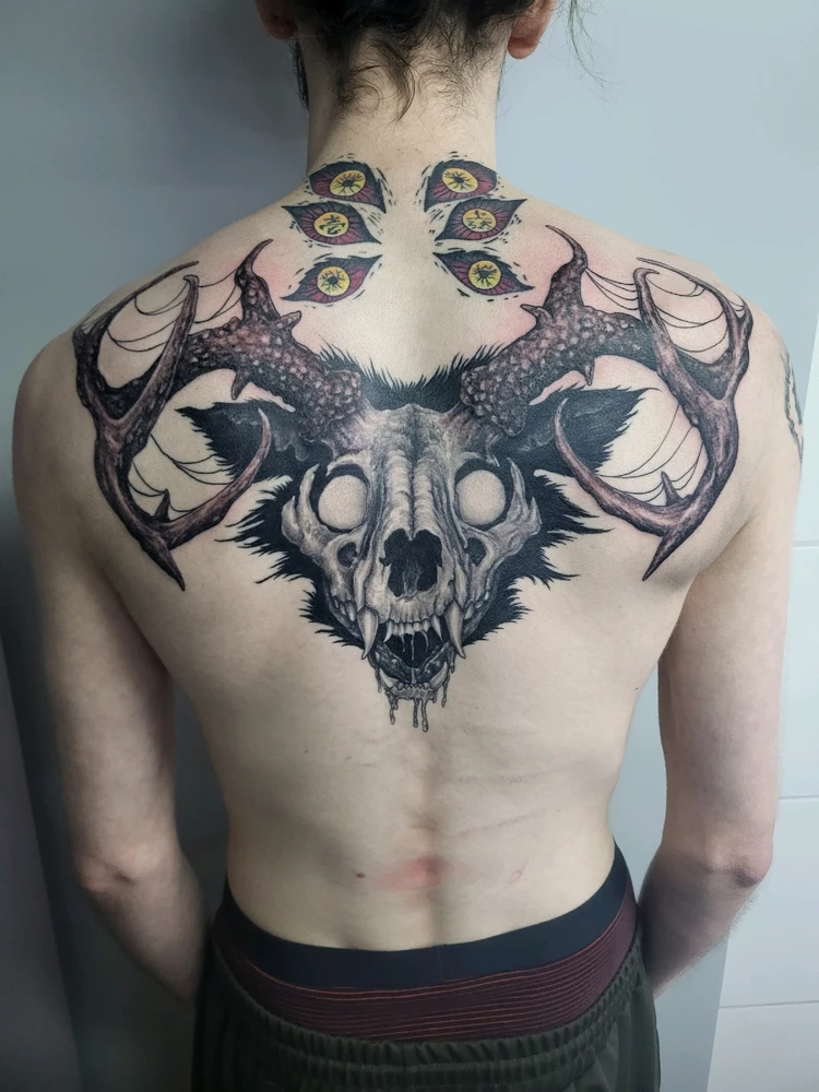 Een rug tattoo in black and gray van een windego schedel