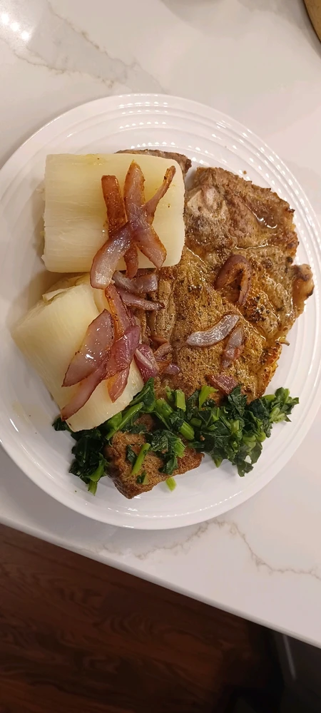 Ribeye Steak with red onions, yuca and Collard Greens. 