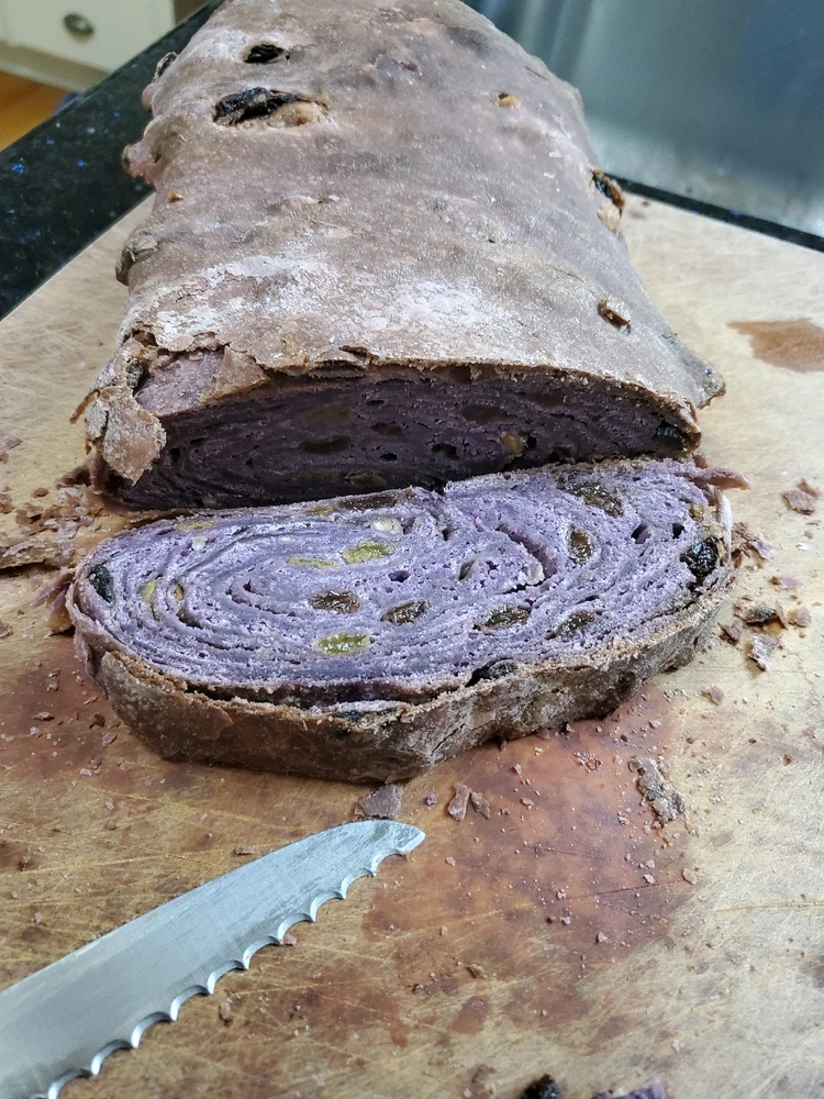 A dubious purple loaf of bread with dried fruit in it.