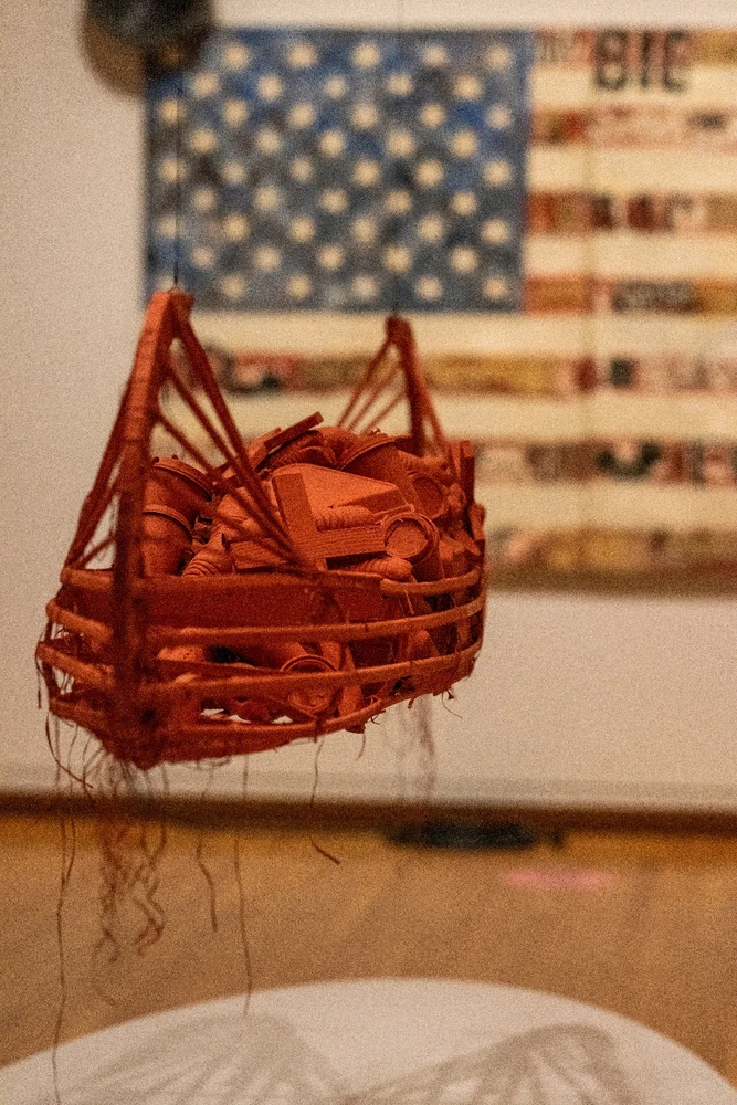 Canoe filled with single use food containers and crosses. American flag in the background. 