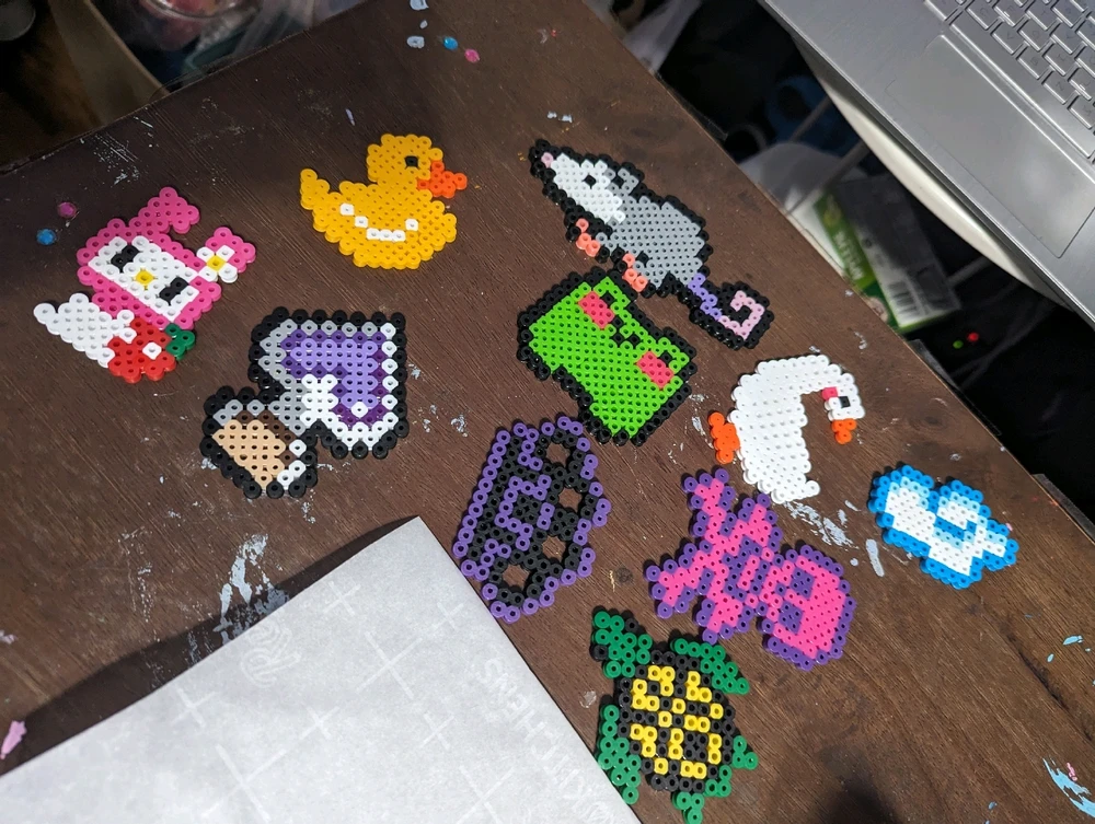 A picture of 10 different finished perler bead creations that look like different animals and characters.