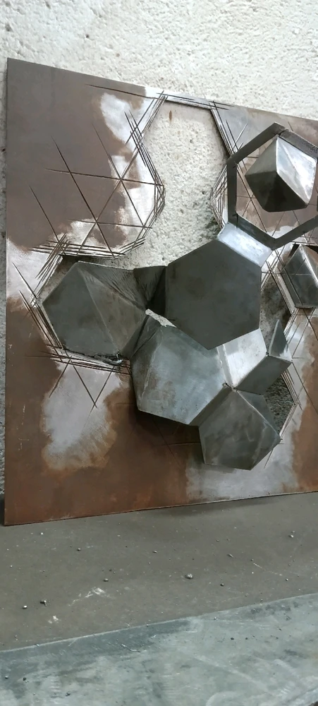 Chapa de acero de 2mm de espesor cortada, plegada (según trama geometría que parte del hexágono) y oxidada parcialmente.