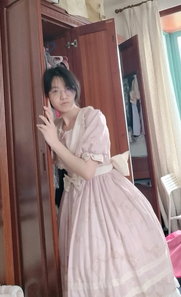 me in a pink lolita dress, posing on my closet. 