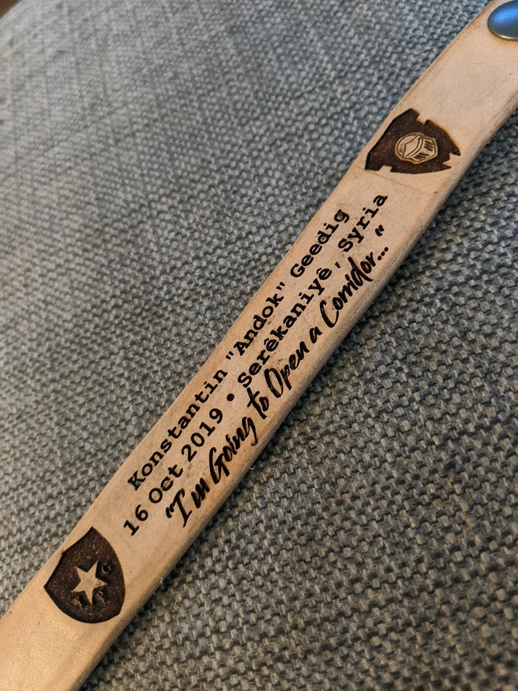 Custom-made laser-etched leather bracelet, with the inscription: Konstantín "Andok" Geedig, 16 October 2019, Serêkaniyê Syria