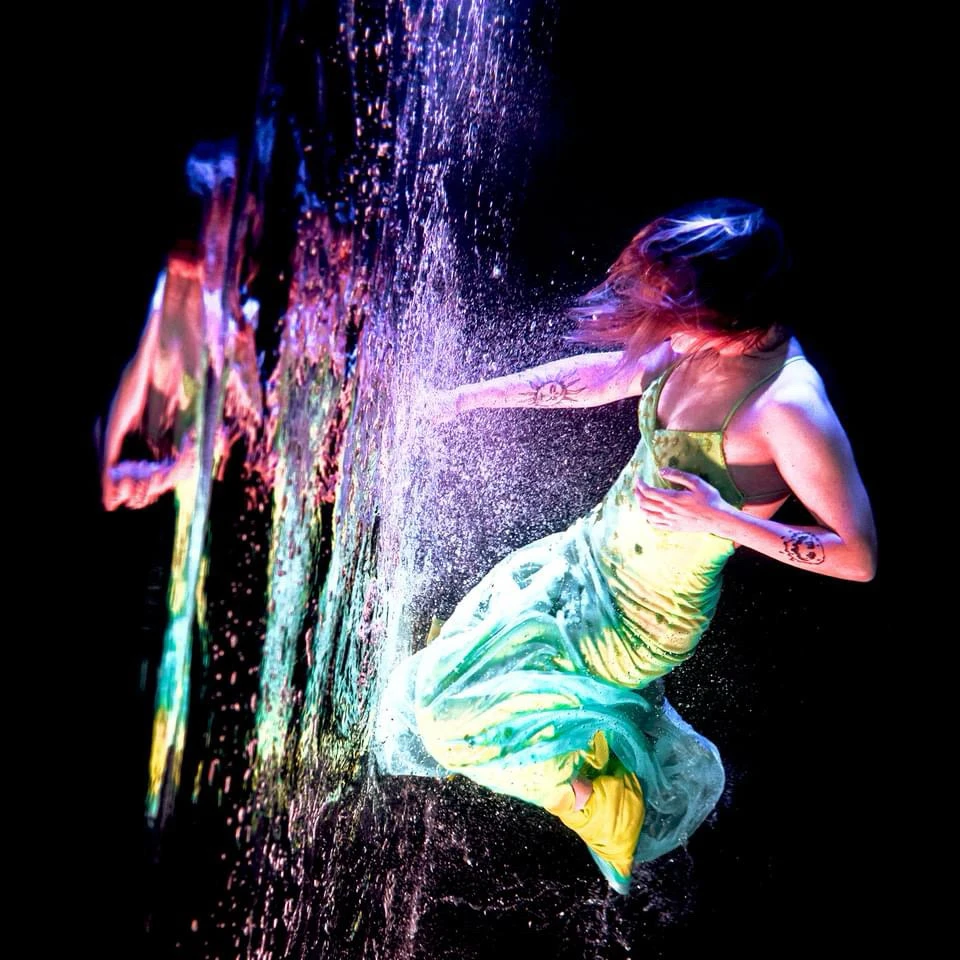 Woman in a dress breaking through the surface of water underwater
