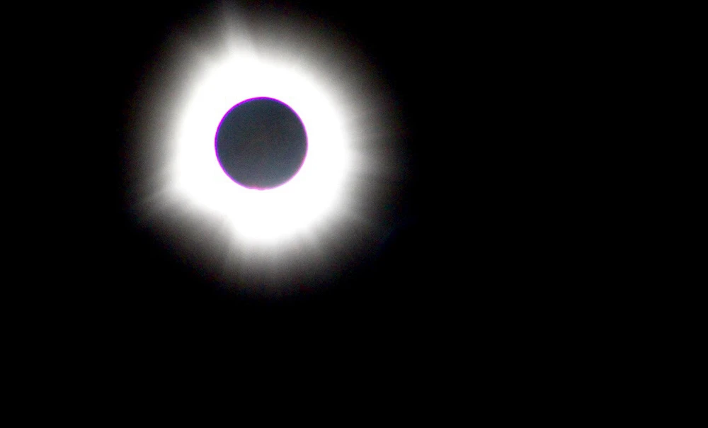 A picture of the eclipse totality. A black dot with bright white rays shooting out from around it! 