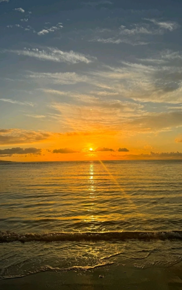 Golden hour sunset. Sea waves crashing over. Blue orange sky. 