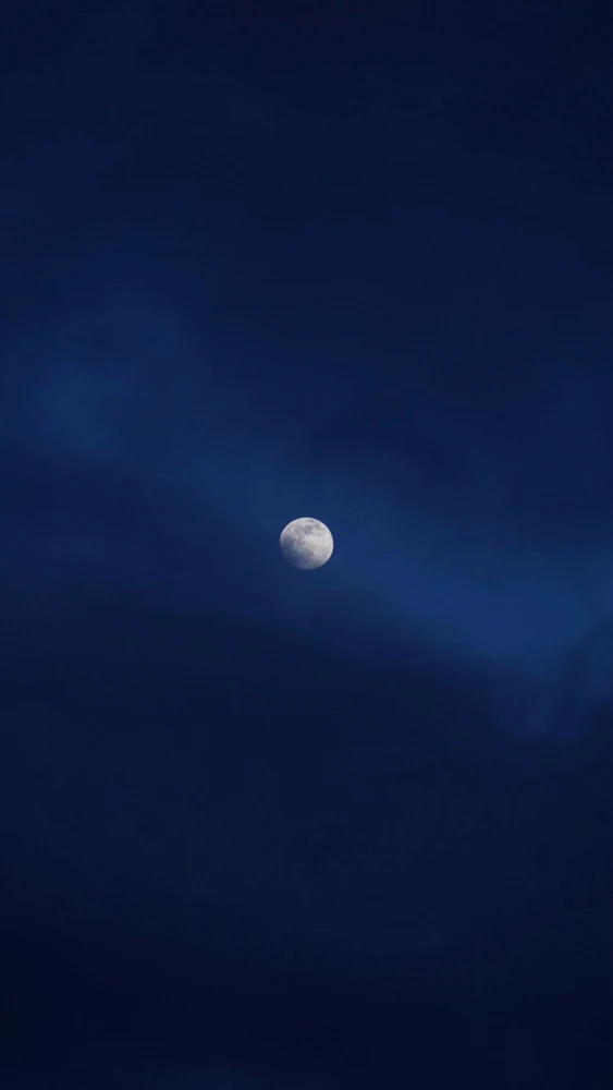 Bright Moon behind dark clouds 