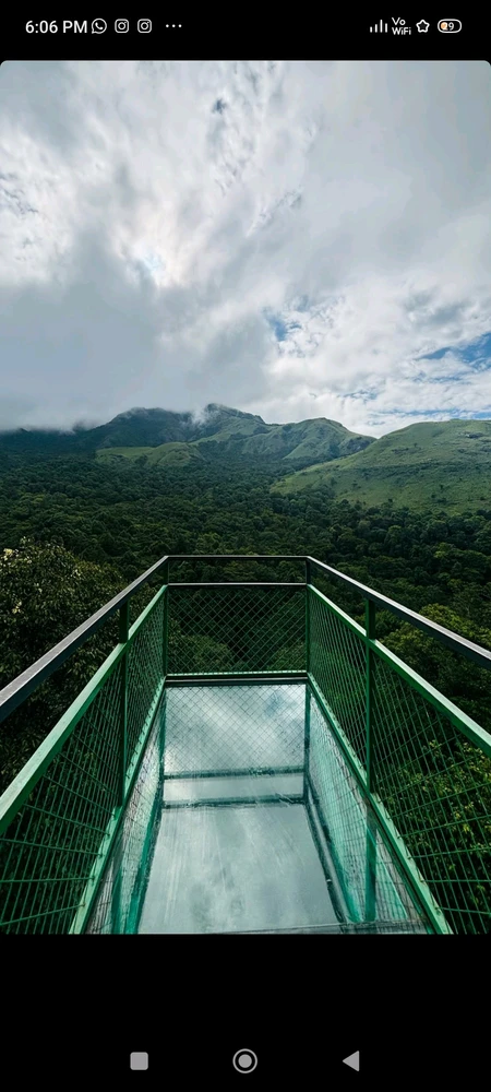 A viewpoint just above a cliff with clouds and hills to see