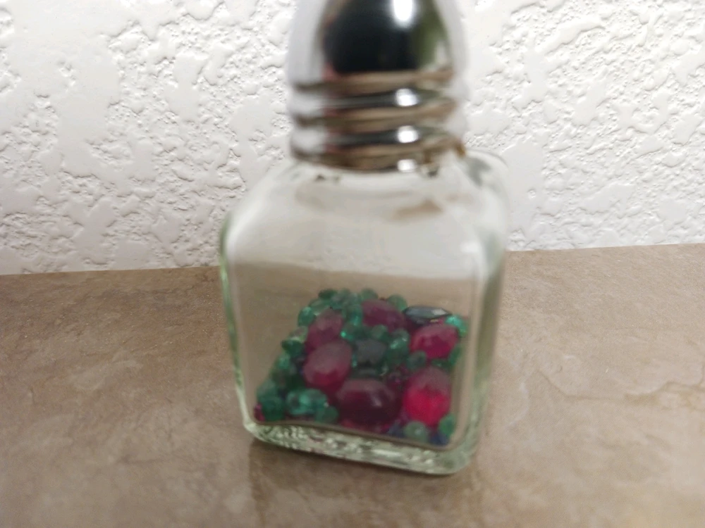 1" square salt shaker with a few small rubies, emeralds, and sapphires inside.