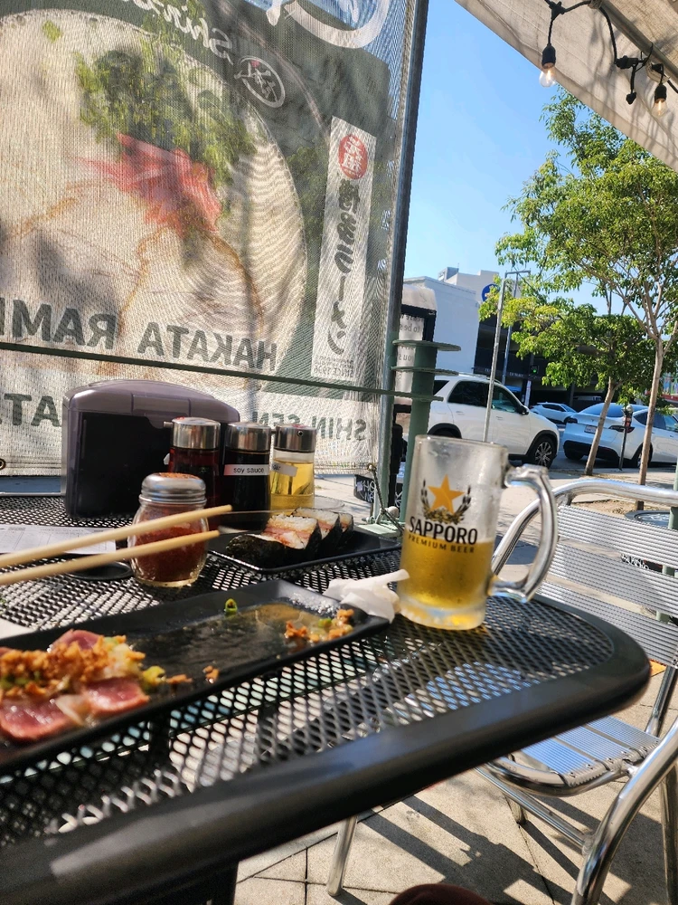 A beer, tuna carpaccio, and gyoza under the downtown sky. 