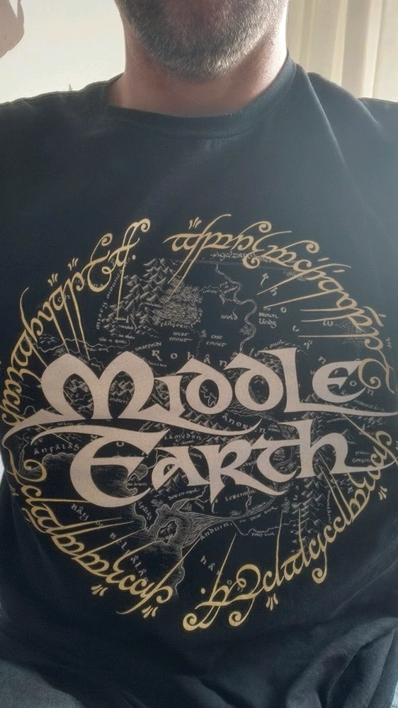A t-shirt with a print on it regarding Lord of the Rings. The map of Middle Earth and around it, the writing of the one ring.