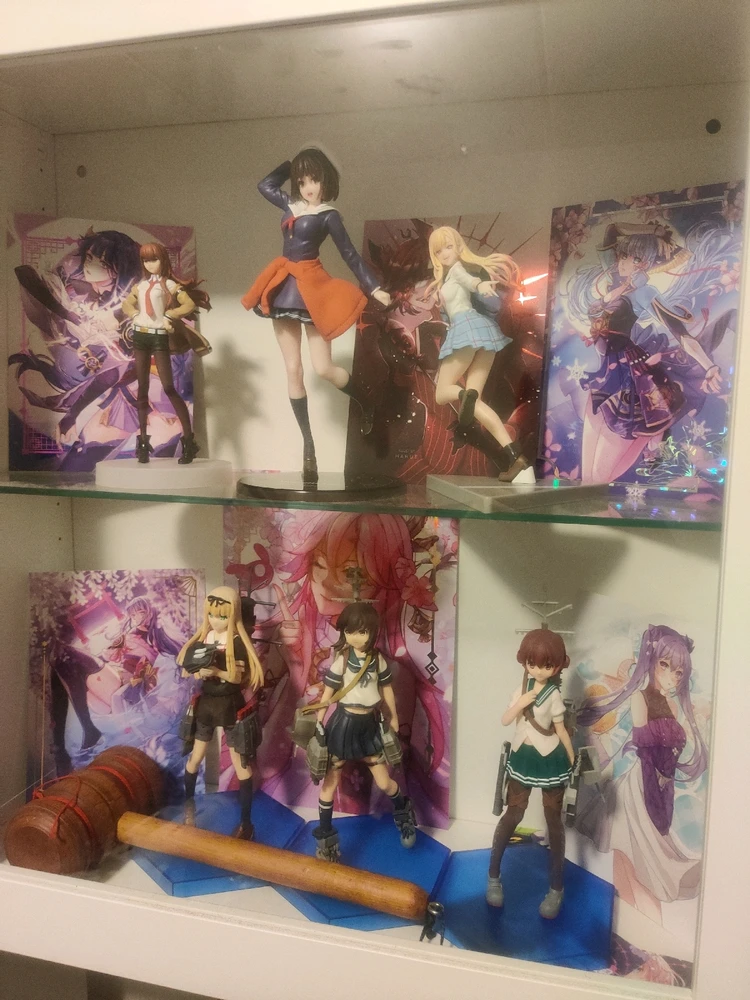 Kuvassa on lasivitriinissä eri tasoilla useampia animefiguureja ja -printtejä.