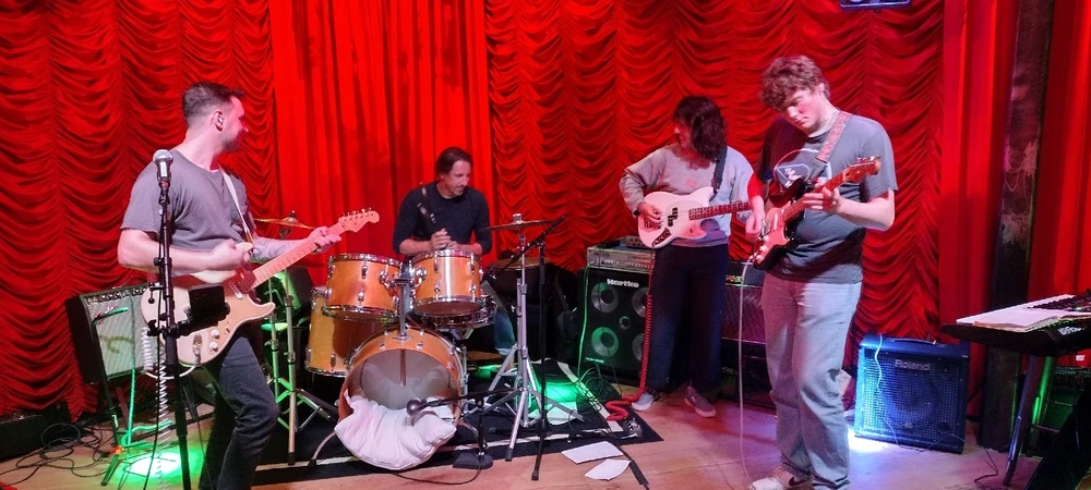 Slow Coast: four guys, three guitars, one drum set, and lots of plush curtains on the stage.