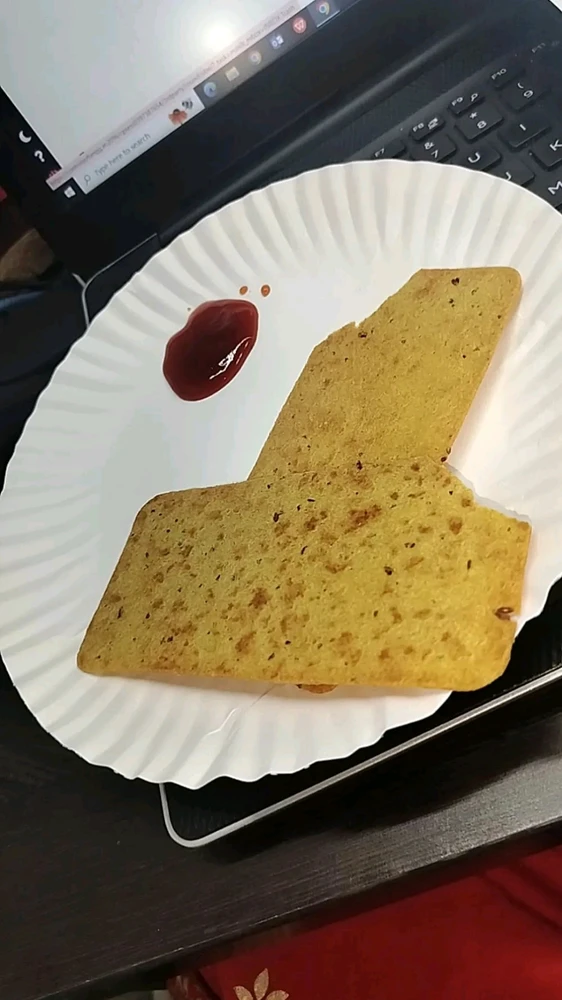 A crispy paper papad served with a dollop of ketchup on the side, ready for a tasty bite.