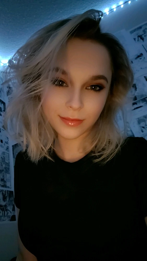 Selfie of a girl with almost white platinum blonde hair in her room. 