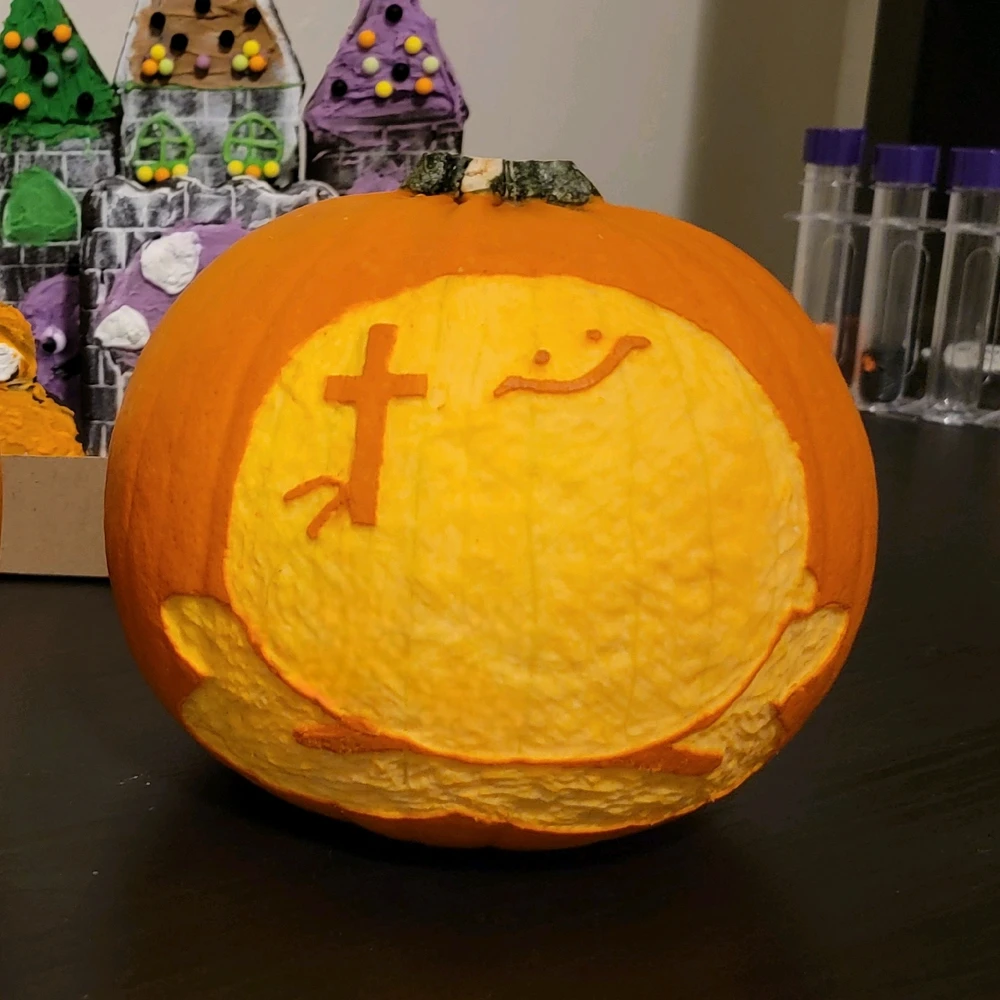 A pumpkin carving of a very Christian Kirbo, holding his cross, ready to annihilate you with the power of Jesus
