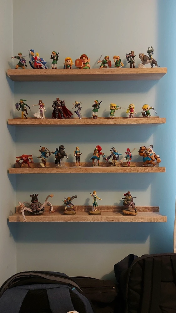 A picture showing several amiibo (figurines) from The Legend of Zelda, collected and displayed on four vertical wall shelves.