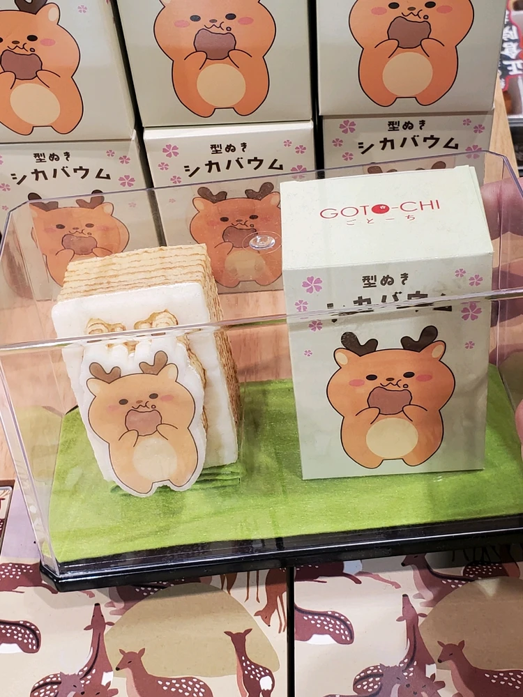 A cookie with a design of a cartoon deer eating a cookie on it.