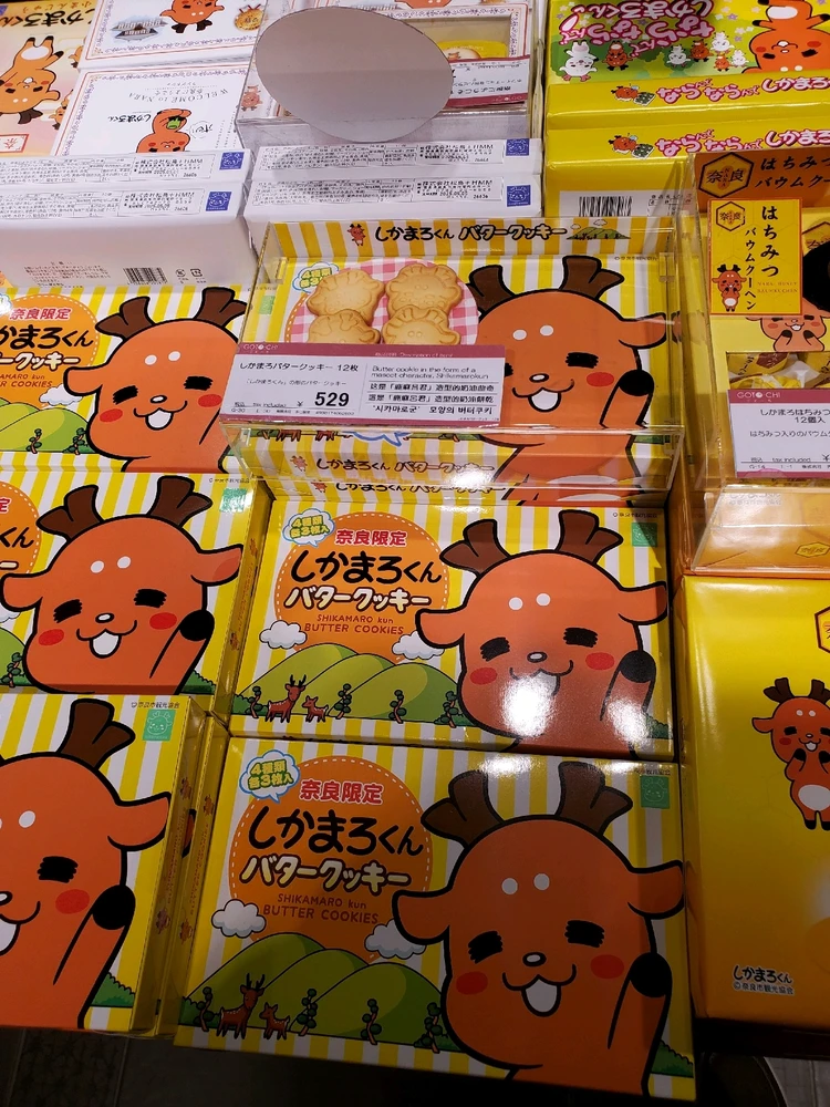 Several boxes of cookies with a cartoon deer on it waving.