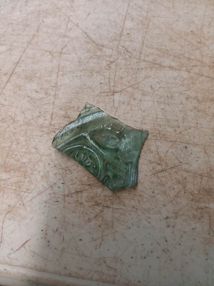 A shard of a cathedral pickle jar, molded with decorations mimicking a cathedral