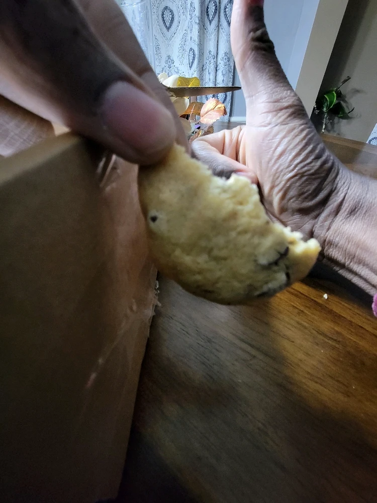 A picture of a half eaten cookie with a black thumbs up hand, indicating the food is delicious.