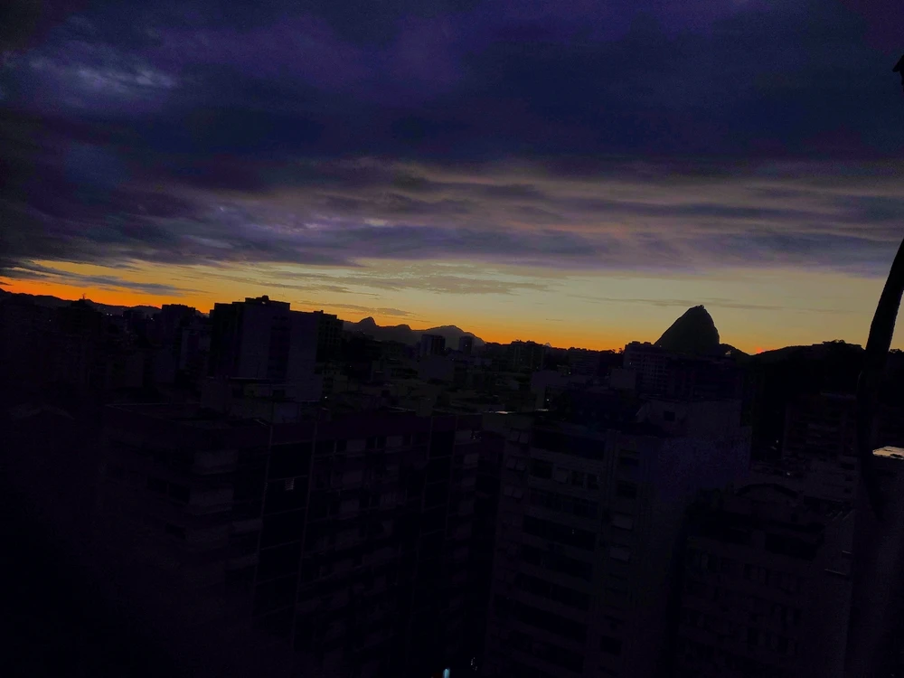 right before the sunrise, the datk blue shades of the sky meet the golden peach glowing from behind the mountain range
