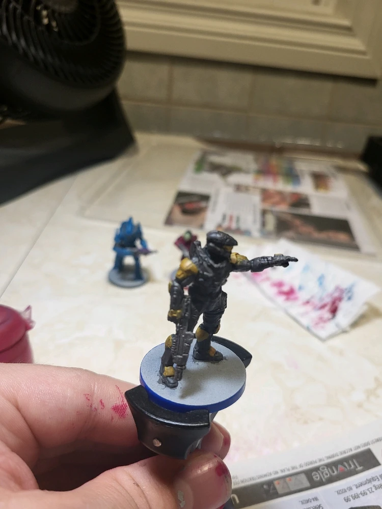 A Spartan Mark 7 for Halo Flashpoint holding a rifle and pointing. This one has been painted gray and gold. From the side.