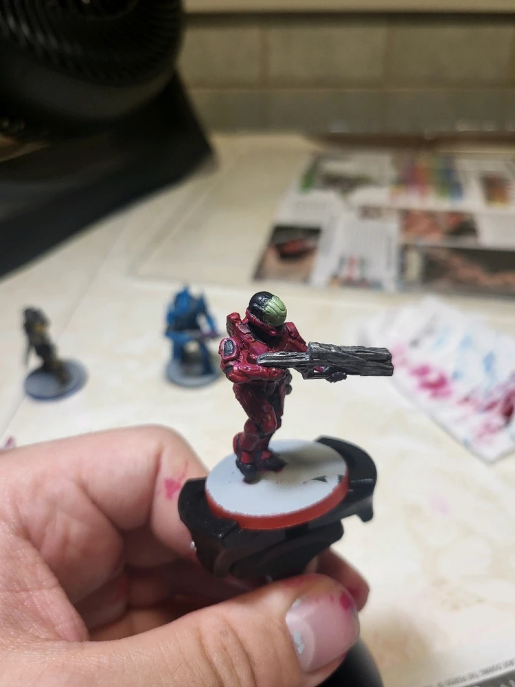 A Spartan Zvezda for Halo Flashpoint holding a launcher and running. This one has been painted pink and blac. From the side.