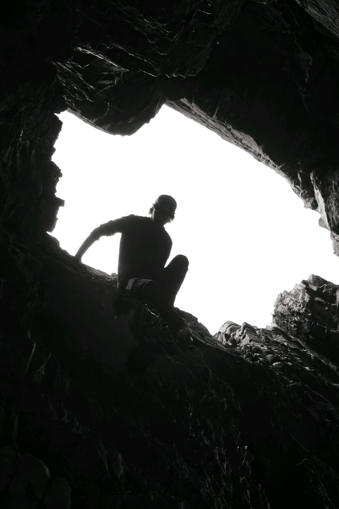 Silhouette climbing down rock near Bow Fiddle Rock