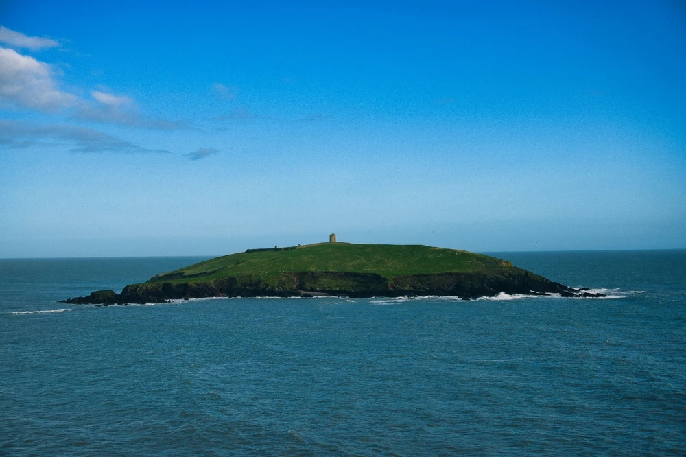 Capel Island, Cork. A small island in the sea with just a single structure, a stone tower. 