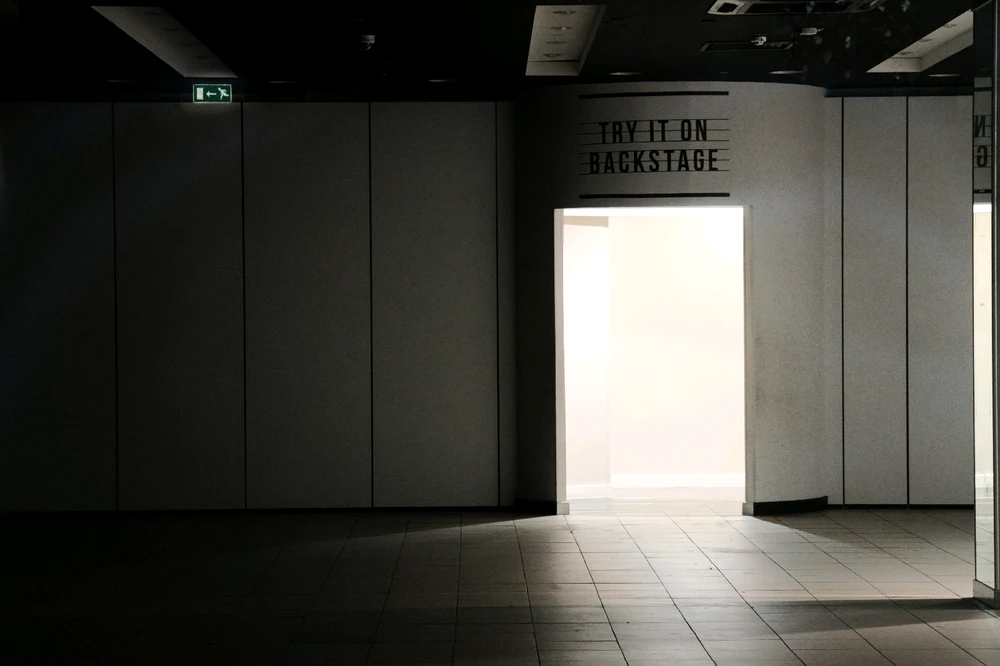 An empty store with the changing room light on in the background. 