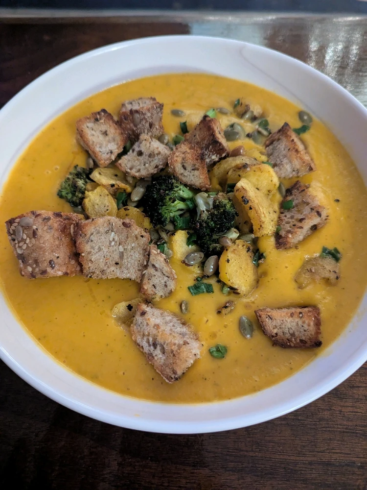Glamour shot of Carrot Ginger soup with toppings