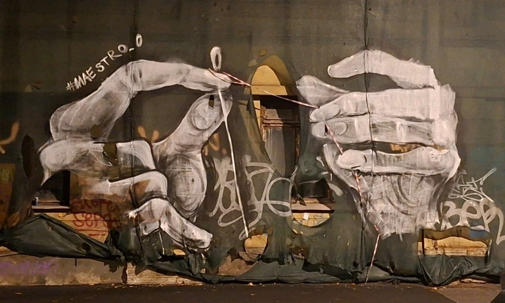 St. Petersburg street art.
The hands sew the construction net with warning tape