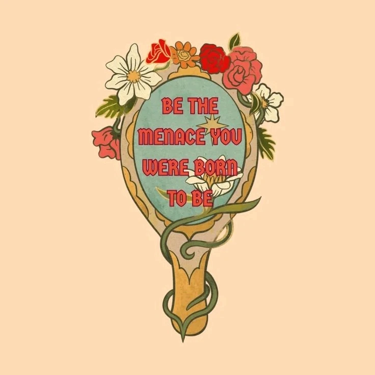 Vintage hand mirror with flowers growing on it and the words "be the menace you were born to be" on the mirror.