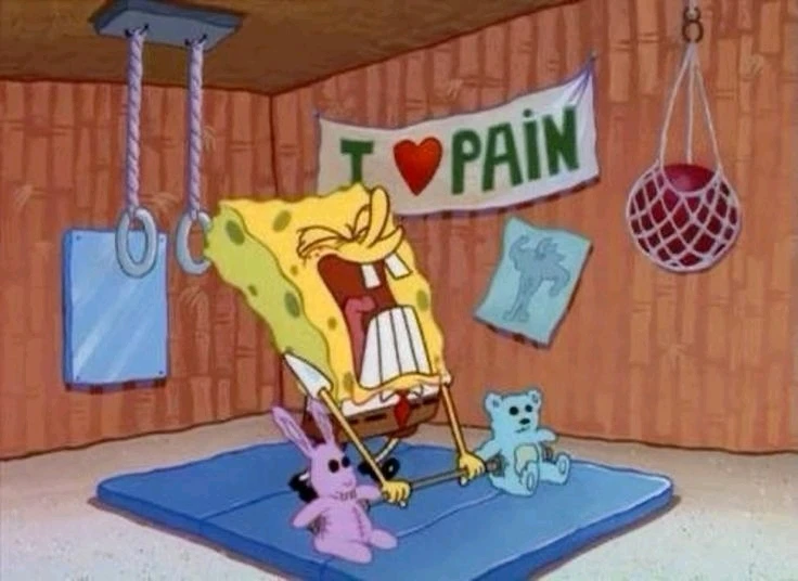 Character SpongeBob straining lifting weights in a home gym but the weights are two stuffed animals. 