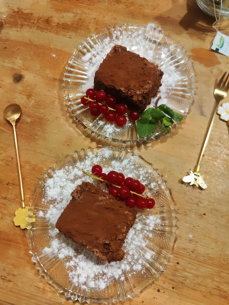 Walnut brownie served with red currants and mint