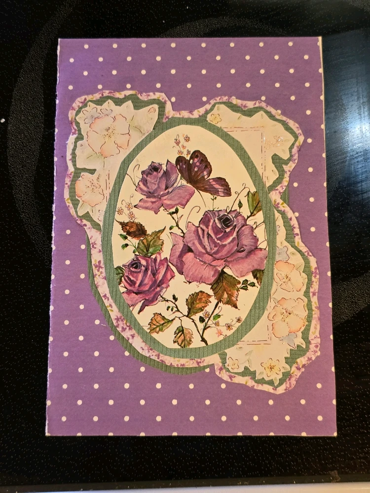 Front of a greeting card featuring roses and other flowers and a butterfly