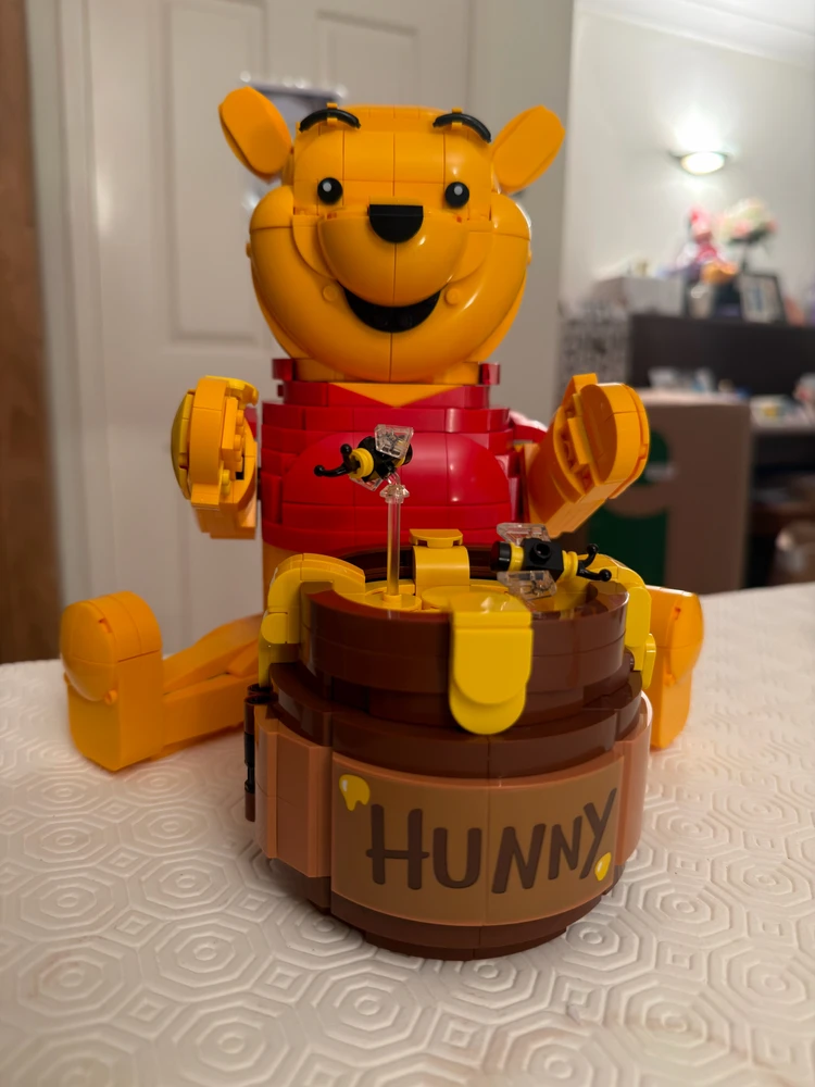 LEGO Winnie-the-Pooh and Eeyore figures in front of a brown LEGO display with archways.