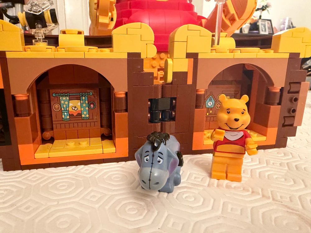 LEGO Winnie-the-Pooh and Eeyore figures in front of a brown LEGO display with archways.