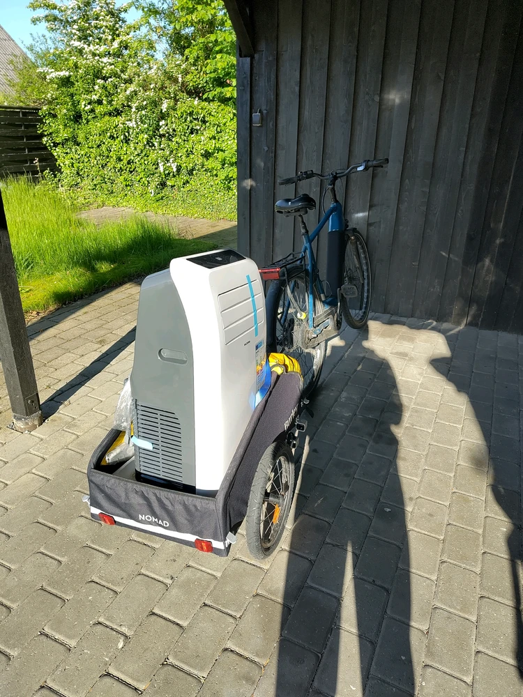 Bike with a trailer amd a big ac on the trailer, but the securing ropes no longer hold the device tied down.